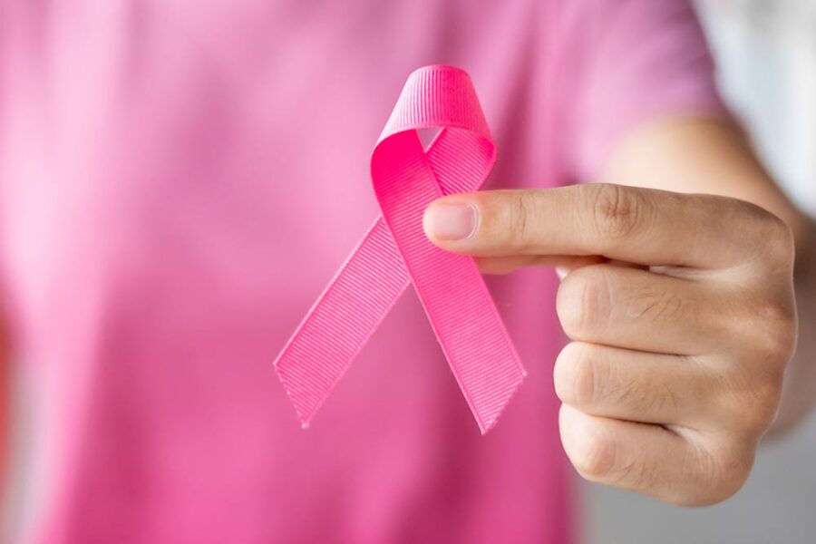 Person holding pink breast cancer ribbon