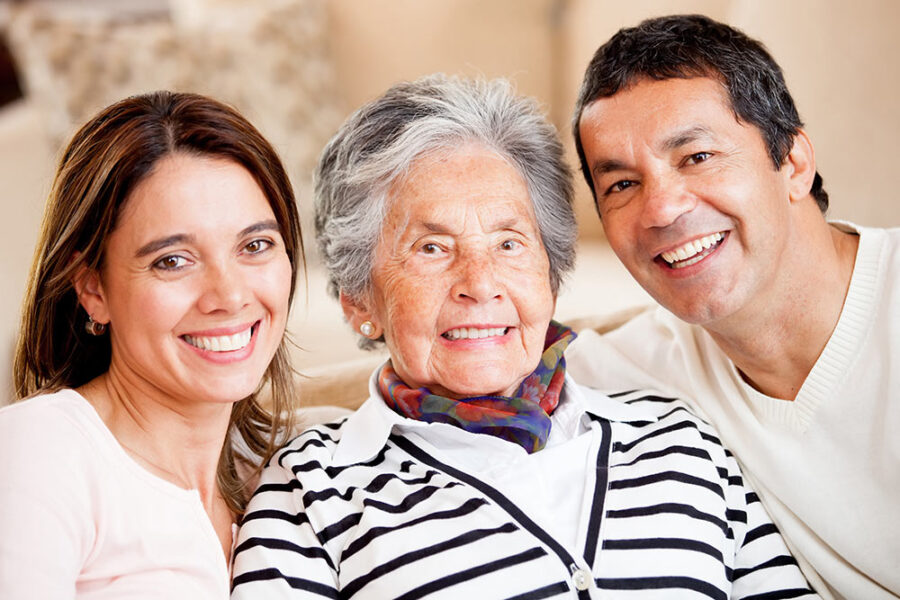 Hispanic couple sitting around elderly parent