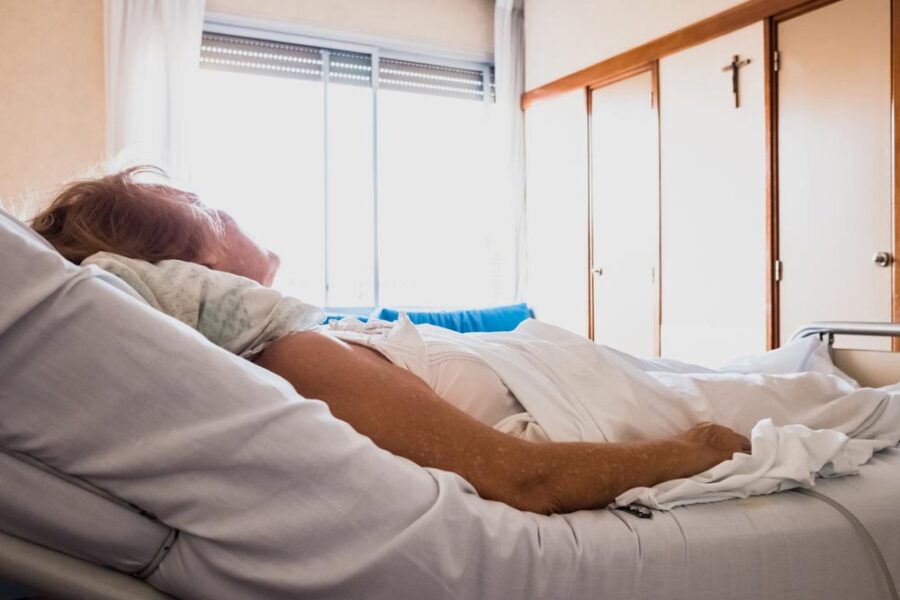 Elderly person alone in a hospital room
