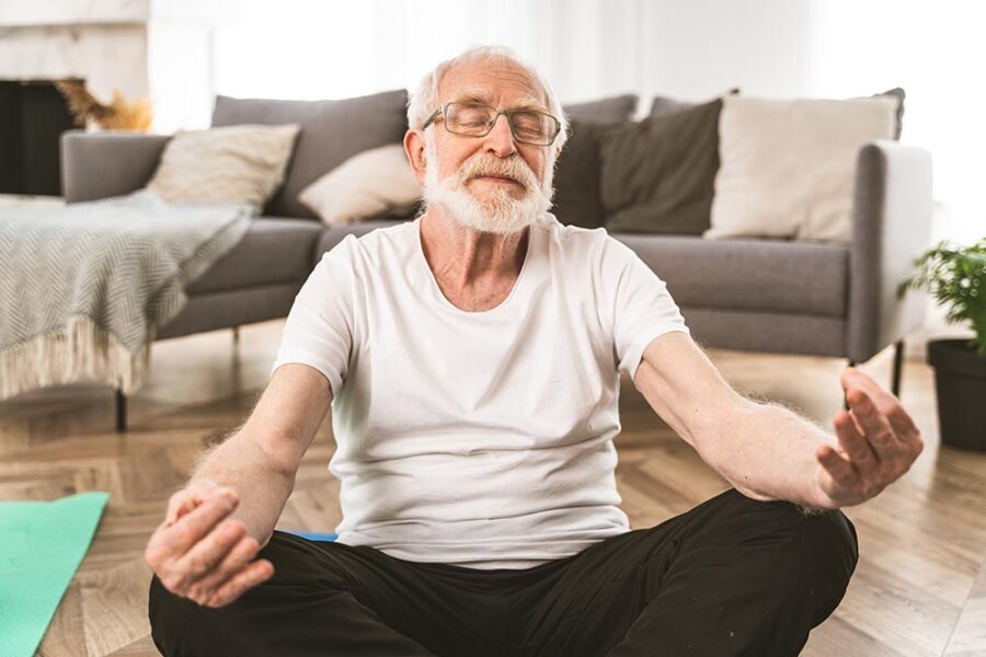 Elderly man meditating on the floor
