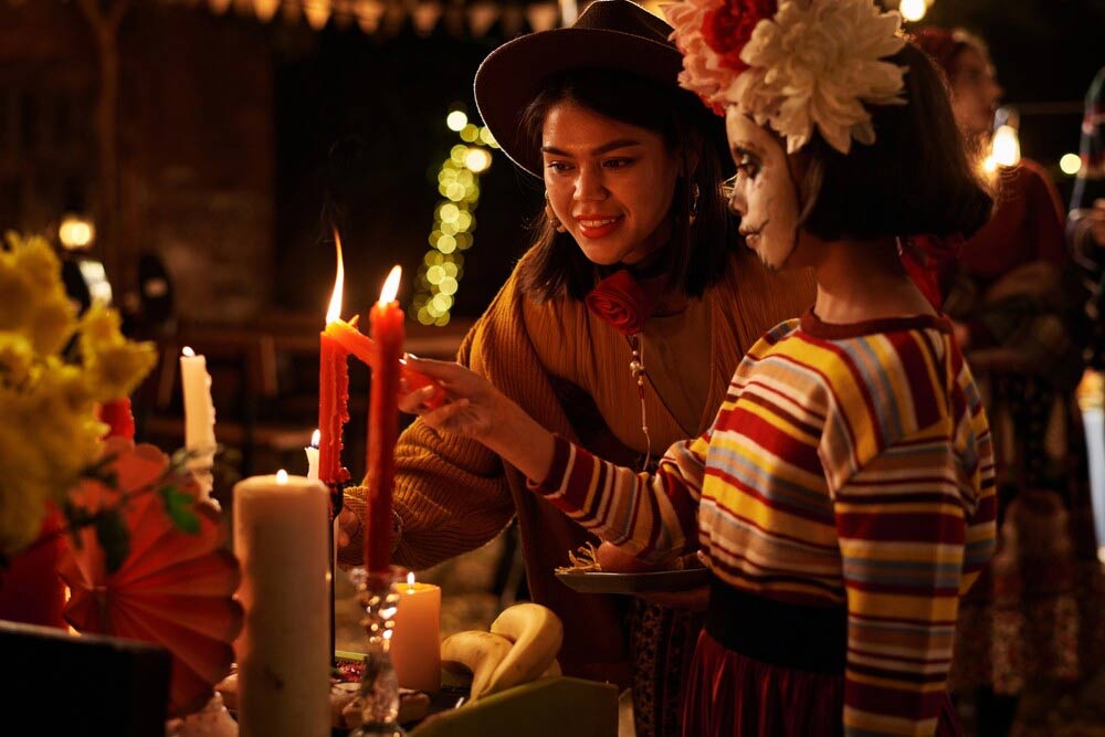 A Hispanic duo lighting candles on the Day of the Dead