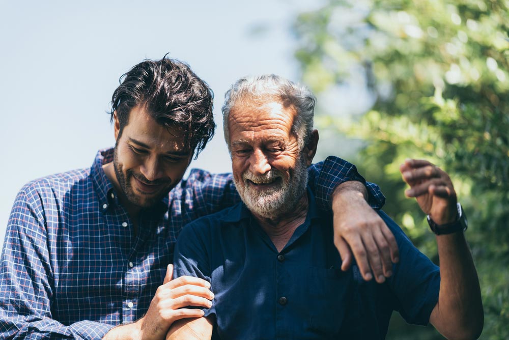 An elderly father and his son laughing together