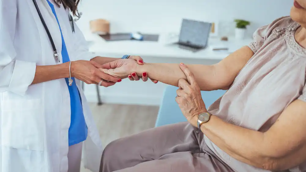 An elderly woman checking her pulse with the help of a doctor