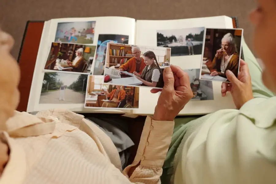 Two elderly people looking at old photographs