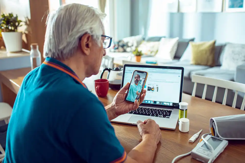 An elderly man on a video call with a doctor