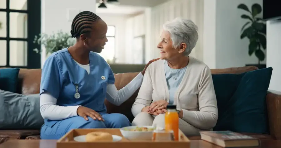 A medical worker comforting an elderly woman on a couch